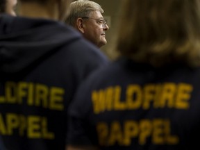 Lorne Dach, NDP critic for agriculture and forestry, is framed by firefighters as he calls on the provincial government to reverse cuts to the Wildland Firefighter Rappel Program (RAP) during a news conference, in Edmonton on Thursday, Nov. 7, 2019.