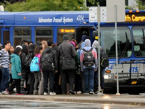 Passengers wait to board an Edmonton Transit Service bus in Edmonton.