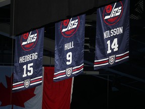 Winnipeg Jets Hall of Fame banners for inductees Anders Hedberg, Bobby Hull and Ulf Nilsson hang from the arena ceiling on Oct. 19, 2016, during their induction ceremony in Winnipeg.