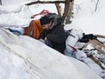 Doug Cooke, Boyle Community Services Street Outreach team lead, hands out warm clothing while visiting a camp site near Alex Taylor School, in Edmonton Thursday Feb. 7, 2019. Five days a week the 8 members of the street outreach team fan out across the city to check on the welfare of Edmonton's homeless population.