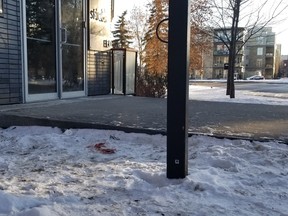 A pool of blood is visible in the snow next to the building's entrance on Thursday, Dec. 26, 2019, as investigators continued to comb the scene of a Christmas Day shooting that left a man, 28, dead at 117 Street and 106 Avenue.
