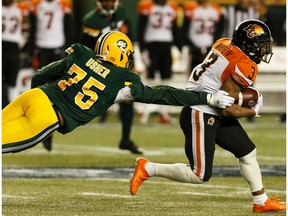 Edmonton Eskimos' Nick Usher (75) reaches for B.C. Lions' John White IV (3) during second half CFL action at Commonwealth Stadium in Edmonton, on Saturday, Oct. 12, 2019.