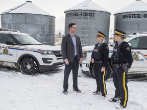 Doug Schweitzer, Minister of Justice  stands with RCMP member Cst. Cheri-Lee Smith and Cst. Amanda Arneil in the yard of a Leduc area dairy farm. The government of Alberta announced on Wednesday that  more than 500 RCMP positions in rural communities will be added in the next five years to combat crime on December 4, 2019.