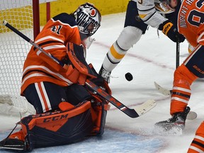 Edmonton Oilers goalie Mike Smith (41) makes the save as Buffalo Sabres Jack Eichel (9) tries for the rebound with Ryan Nugent-Hopkins (93) during NHL action at Rogers Place in Edmonton, December 8, 2019. Ed Kaiser/Postmedia