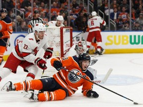 Edmonton Oilers' Ryan Nugent-Hopkins (93) is tripped by Carolina Hurricanes' Brett Pesce (22) during the third period of a NHL hockey game at Rogers Place in Edmonton, on Tuesday, Dec. 10, 2019.