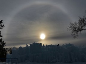 A sun dog, formally called a parhelion in meteorology, is an atmospheric optical phenomenon appears in the sky as workers build the Ice Castles at Hawrelak Park in Edmonton, December 16, 2019.