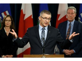 Travis Toews (centre), President of Treasury Board and Minister of Finance, speaks during a press conference at the Alberta Legislature announcing a panel looking into the reform of Alberta's automobile insurance system in Edmonton, on Wednesday, Dec. 18, 2019. The panel are comprised of Chris Daniel (not shown), consumer representative with the Automobile Insurance Rate Board, Shelley Miller (left), auto insurance reform lawyer and Dr. Larry Ohlhauser (right), chief medical advisor to the superintendent of insurance.