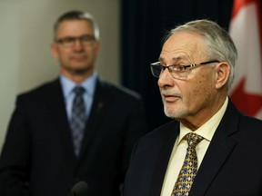 Justice Minister Travis Toews, left, listens as Chris Daniel, consumer representative with the Automobile Insurance Rate Board, speaks on Wednesday, Dec. 18, 2019, during a news conference at the Alberta legislature announcing a panel looking into the reform of Alberta's automobile insurance system.