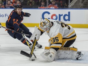 Connor McDavid (97) of the Edmonton Oilers tries to poke the puck past goaltender Tristan Jarry (35) of the Pittsburgh Penguins at Rogers Place in Edmonton on Friday, Dec. 19, 2019.