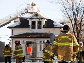 Edmonton Fire Rescue Service firefighters douse hot spots after a fire broke out in an abandoned house at 11939 101 St. NW in Edmonton, on Sunday, Dec. 22, 2019.
