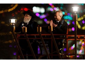 Chabad Lubavitch of Edmonton's executive director Rabbi Ari Drelich, left, and Edmonton West MP Kelly McCauley light the Alberta legislature's menorah during a public Chanukah Celebration in Edmonton, on Sunday, Dec. 22, 2019.