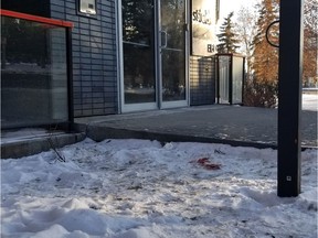 A pool of blood is visible in the snow next to the building's entrance on Thursday, December 26, 2019, as investigators continued to comb the scene of a Christmas Day shooting that left a man, 28, dead at 117 Street and 106 Avenue.