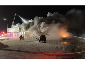Fire crews work on a fire at the Edson Honda dealership Monday morning