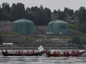 Canoeists paddle first nation canoes past the Kinder Morgan facility in Burrard Inlet in North Vancouver, B.C. Thursday, May, 22, 2014.Four British Columbia Indigenous groups are set to argue in the Federal Court of Appeal that the Canadian government failed to consult adequately with them before its latest approval of the Trans Mountain pipeline expansion.