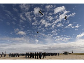 Three 408 Tactical Helicopter Squadron helicopters perform a fly past during the national anthem as the squadron commemorates the Battle of Britain at CFB Edmonton in Namao, Alberta on Sunday, Sept. 18, 2016.