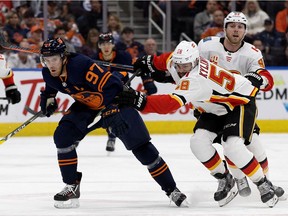 The Edmonton Oilers' Connor McDavid (97) battles the Calgary Flames' Oliver Kylington (58) during second period NHL action at Rogers Place, in Edmonton Friday Dec. 27, 2019.