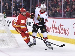 Ottawa Senators defenseman Thomas Chabot battles for the puck with Calgary Flames center Dillon Dube during the third period at Scotiabank Saddledome. Flames won 3-1.