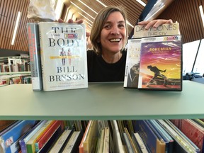 Collections librarian Mary Bennett shows off some of the most-borrowed books and videos of 2019 at the Capilano branch library in Edmonton on Monday, Jan. 6, 2020.