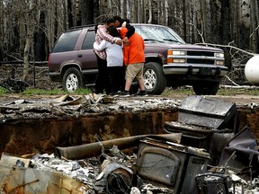 Paddle Prairie Metis Settlement residents Angie and Ronnie Cardinal and their children are overcome with grief after seeing the remains of their home on Thursday June 20, 2019. All residents of the community were evacuated four weeks ago when a wildfire swept through Alberta's largest Metis settlement and destroyed at least 15 homes. None of the residents had insurance for their homes. The settlement is located 660 kilometres north of Edmonton, Alberta.