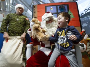 Teddy Toth, 4, receives a teddy bear from Santa Claus at the Stollery Children's Hospital, in Edmonton Wednesday Dec. 11, 2019. Santa was flown in to the hospital by the Edmonton Garrison's 408 Tactical Helicopter Squadron (THS). Squadron personnel donated more than $1,000 to purchase more than 100 teddy bears to bring to the children at the hospital.