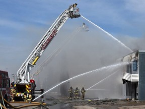 Firefighters battle a blaze that broke out in Jasper Autoworks Edmonton, May 17, 2019.