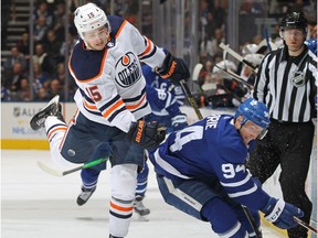 Josh Archibald (15) of the Edmonton Oilers side steps a hit from Tyson Barrie (94) of the Toronto Maple Leafs during an NHL game at Scotiabank Arena on Jan. 6, 2020 in Toronto.