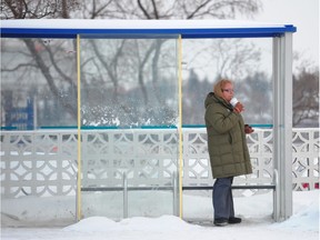 A transit user waits for the bus on Jasper Avenue and 121 Street. File photo.