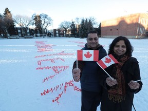 Sanjeev, left and Sangeeta Chawla stand in front of their New Years Day display outside Oliver School. They hoped to inspire a message of peace and unity for the upcoming year.