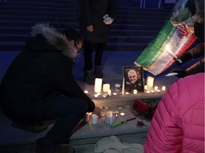 Iranian Canadians at the Alberta legislature on Sunday light candles in front of a picture of Iranian General Qassem Soleimani, killed in a U.S. airstrike in Iraq Friday.