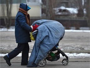 A woman with a stroller is all bundled up while walking along 112 Street near the university on Tuesday, Jan. 7, 2020, as forecasts are calling for much colder temperatures later in the week and weekend.