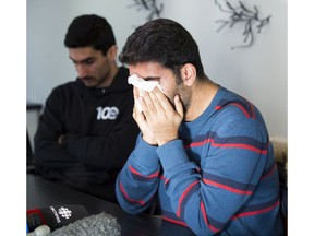 Ramin Fathian weeps as he talks about his friend Nasim Rahmanifar who was killed in a plane crash minutes after takeoff Wednesday, from Tehran's main airport. His friend Sina Esfandiarpour, left, listens as he talks on Wednesday, Jan. 8, 2020, in Edmonton.