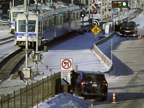 Transit employees manually operate the rail crossing arms on 111 Street just south of 51 Avenue on Tuesday, Jan. 14, 2020.