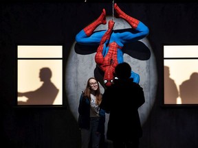 A pair stops for a photo with Spiderman during Dark Matters at the TELUS World of Science Edmonton on Thursday, Jan. 23.