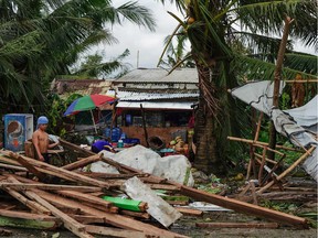 A resident looks at a house damaged at the height of Typhoon Phanfone in Tacloban, Leyte province in the central Philippines on Dec. 25, 2019.