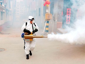 A worker in protective suit disinfects the Dongxinzhuang village, as the country is hit by the new coronavirus, in Qingdao, Shandong province, China January 29, 2020.