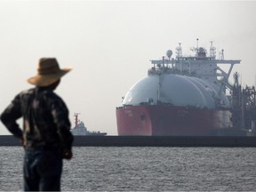 A man looks out towards a liquefied natural gas (LNG) tanker berthed at Tokyo Electric Power Co.'s (Tepco) Futtsu gas-fired thermal power plant in Futtsu, Chiba Prefecture, Japan. File photo.