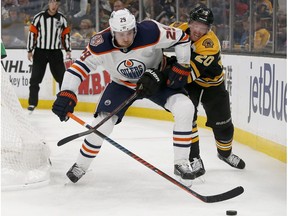 Edmonton Oilers center Leon Draisaitl (29) looks to clear the puck from behind the net ahead of Boston Bruins center Joakim Nordstrom (20) during the second period of an NHL hockey game Thursday, Oct. 11, 2018, in Boston.