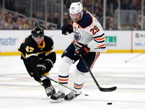 Boston Bruins defenceman Torey Krug knocks the puck away from Edmonton Oilers centre Leon Draisaitl on Jan. 4, 2020, during NHL action at TD Garden.