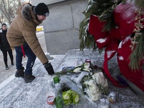 Seth Rimmer lays flowers at a small memorial for Edmontonians killed in the Iranian plane crash on the steps to the Alberta legislature in Edmonton on Thursday, Jan. 9, 2020.