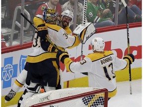 Nashville Predators goalie Pekka Rinne, left, celebrates with defenseman Roman Josi, center, and center Nick Bonino after scoring a goal against the Chicago Blackhawks during the third period of an NHL hockey game in Chicago, Thursday, Jan. 9, 2020.