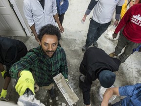 Eskias Worku applies drywall mud to the seam on a new wall built for demonstration. Ideal Contract Services hosted a hands-on event that allowed about 75 participants to use power tools, paint brushes and other tools & materials used in building walls for new construction on January 22, 2020. Photo by Shaughn Butts / Postmedia