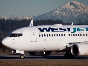 File photo: A pilot taxis a Westjet Boeing 737-700 plane to a gate after arriving at Vancouver International Airport in Richmond, B.C., on February 3, 2014.