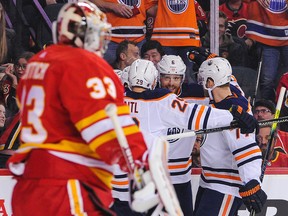 The Edmonton Oilers celebrate after their teammate, Kailer Yamamoto (not pictured) scored against David Rittich of the Calgary Flames, left, at Scotiabank Saddledome on Saturday, Feb. 1, 2020 in Calgary.