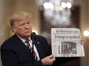 U.S. President Donald Trump holds a copy of The Washington Post as he speaks in the East Room of the White House one day after the U.S. Senate acquitted on two articles of impeachment, on Feb. 6, 2020 in Washington, DC. After five months of congressional hearings and investigations about President Trumps dealings with Ukraine, the U.S. Senate formally acquitted the president on Wednesday of charges that he abused his power and obstructed Congress.