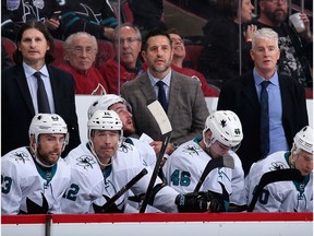 Coaches (top L-R) Mike Ricci, head coach Bob Boughner and Roy Sommer of the San Jose Sharks watch from the bench during the third period of the NHL game against the Arizona Coyotes at Gila River Arena on January 14, 2020 in Glendale, Arizona. The Coyotes defeated the Sharks 6-3.