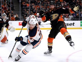 Connor McDavid #97 of the Edmonton Oilers chases after the puck after knocking Matt Irwin #52 of the Anaheim Ducks off balance during the second period at Honda Center on February 25, 2020 in Anaheim, California.