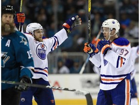 Edmonton Oilers teammates Connor McDavid (97) and Leon Draisaitl celebrate next to Joe Thornton of the San Jose Sharks after McDavid scored an empty net goal during Game 6 of the Western Conference first round of the 2017 NHL Stanley Cup Playoffs at SAP Center on April 22, 2017 in San Jose.