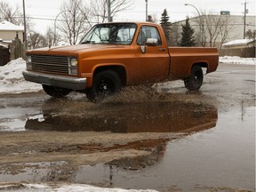 A pickup rips through a puddle at 99 Street and 79 Avenue in Edmonton, on Wednesday, Feb. 5, 2020. Warm weather has seen snow and ice melting across the city.