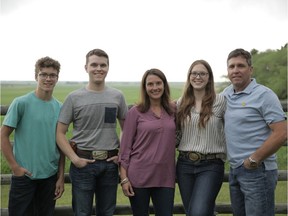 Matt Sawye, right,
stands with his family on their farm outside Acme.