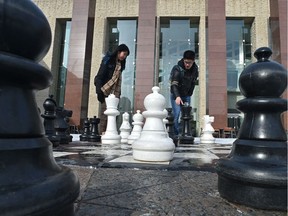Eric Lai and Yuii Han playing larger then life chess out front of city hall in Edmonton, February 16, 2020.